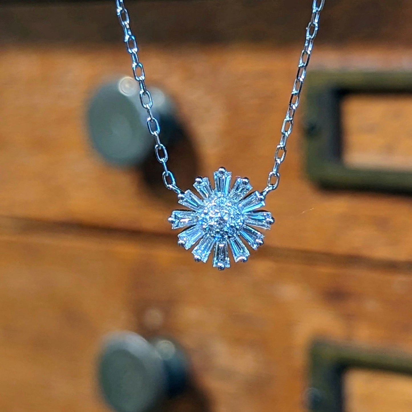 Photo of Diamond Burst Necklace in a decorative scene, designed by , available at Plumb Gold & Plumb Silver