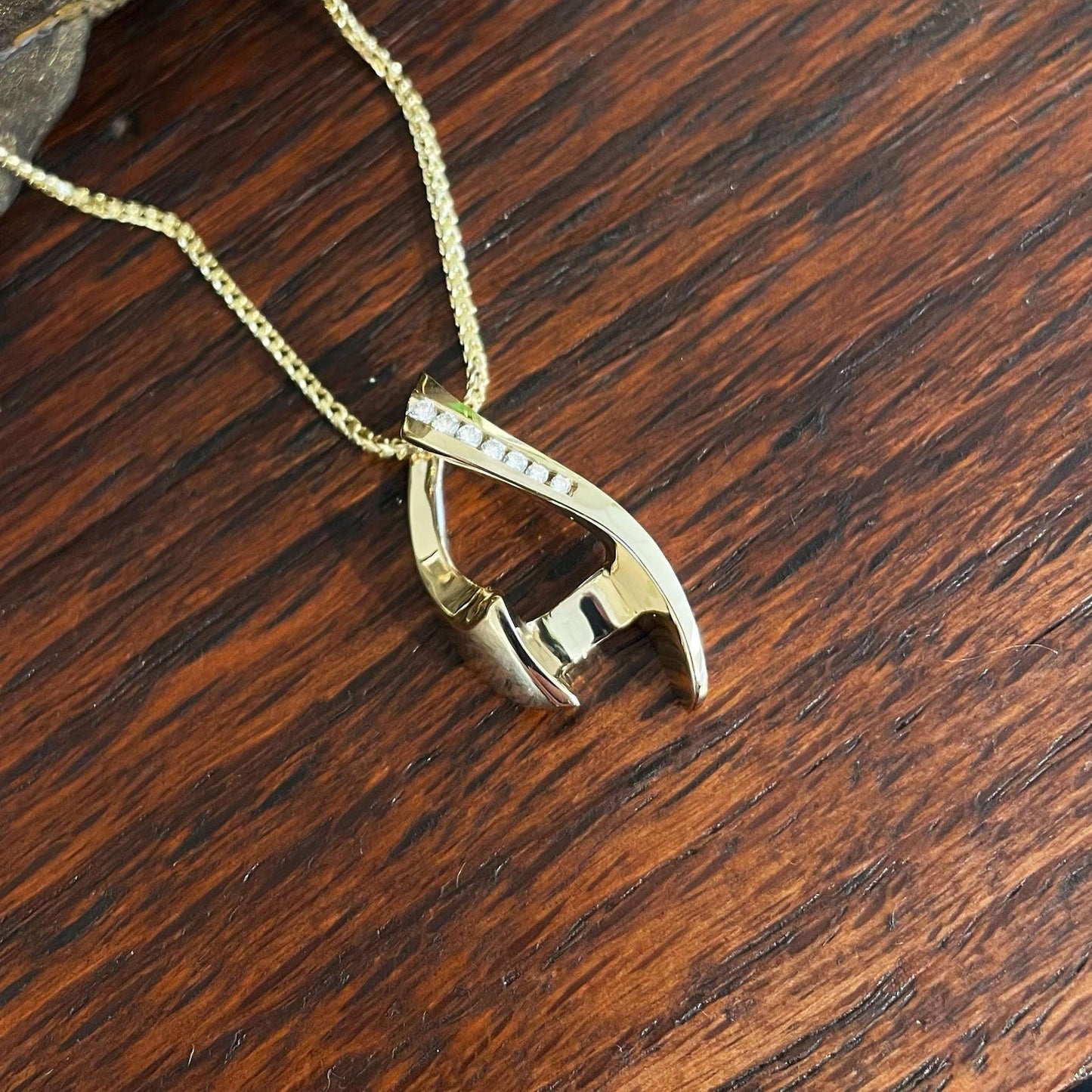 Photo of Diamond Chevron Pendant in a decorative scene, designed by , available at Plumb Gold & Plumb Silver