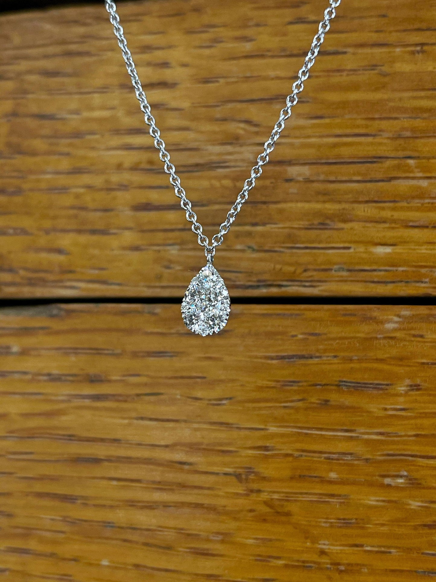 Photo of Diamond Cluster Necklace in a decorative scene, designed by , available at Plumb Gold & Plumb Silver