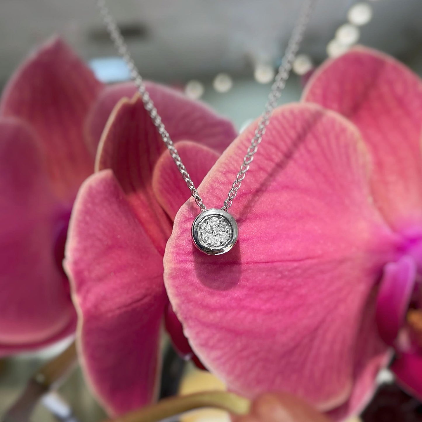 Photo of Diamond Cluster Pendant in a decorative scene, designed by , available at Plumb Gold & Plumb Silver