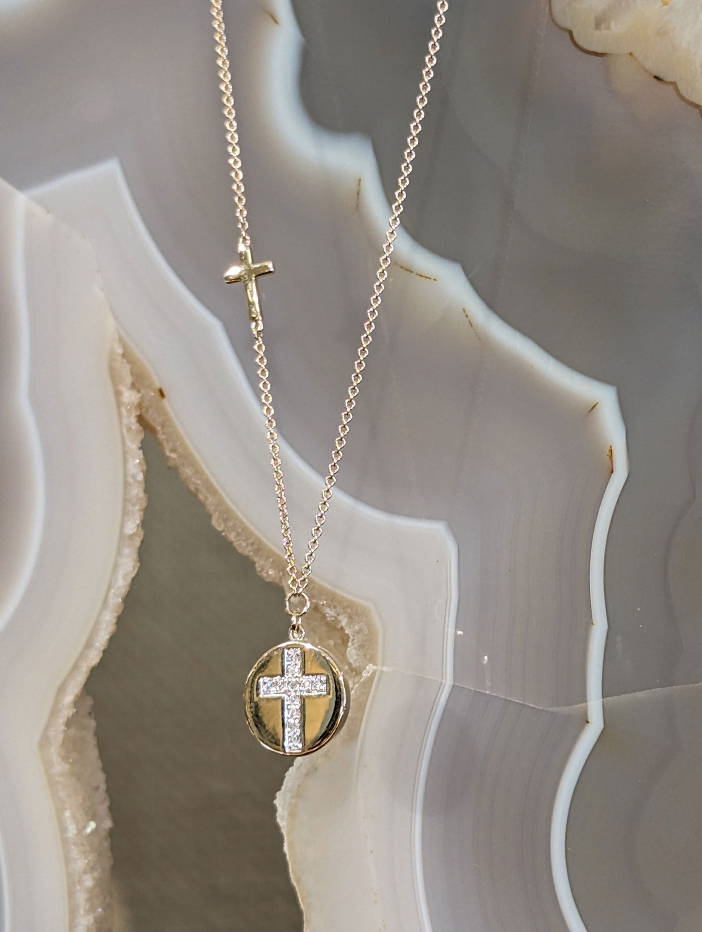 Photo of Diamond Cross Disc Necklace in a decorative scene, designed by , available at Plumb Gold & Plumb Silver