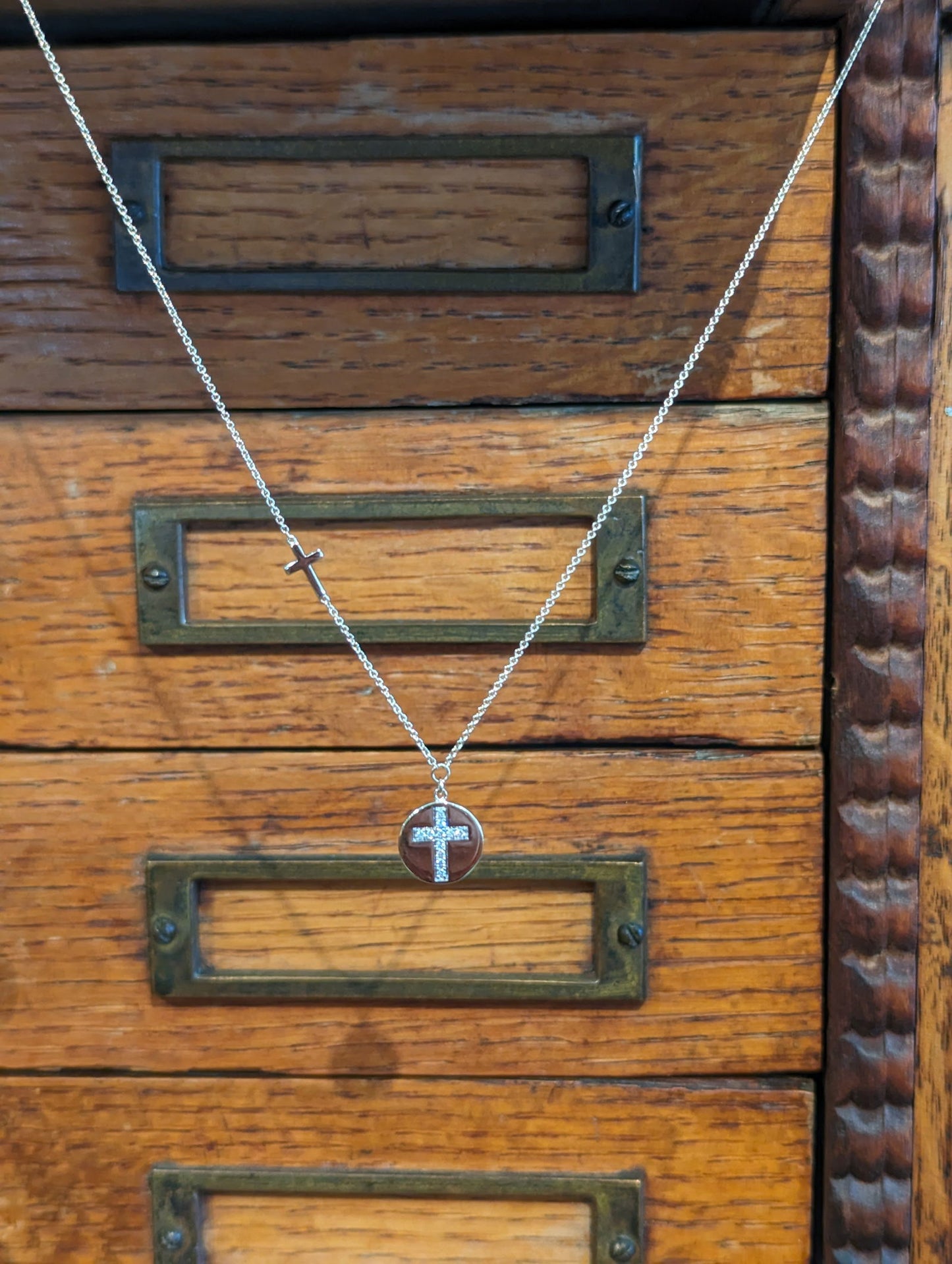Photo of Diamond Cross Disc Necklace in a decorative scene, designed by , available at Plumb Gold & Plumb Silver