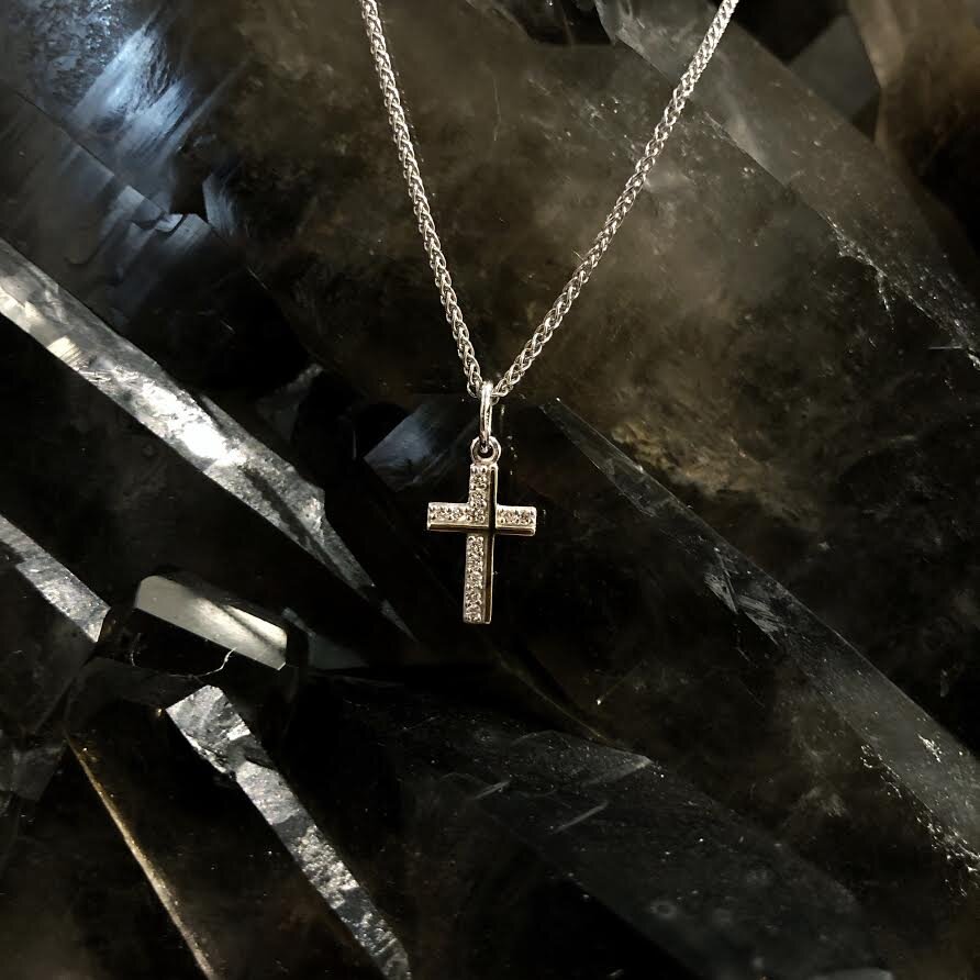 Photo of Diamond Cross Pendant in a decorative scene, designed by , available at Plumb Gold & Plumb Silver