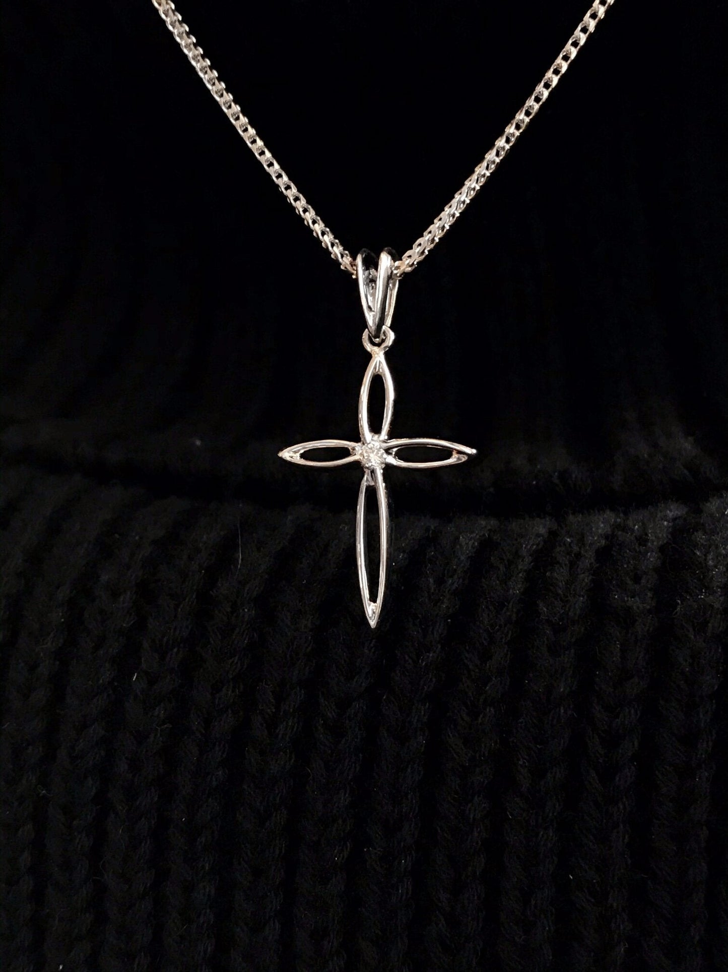 Photo of Diamond Cross Pendant in a decorative scene, designed by , available at Plumb Gold & Plumb Silver
