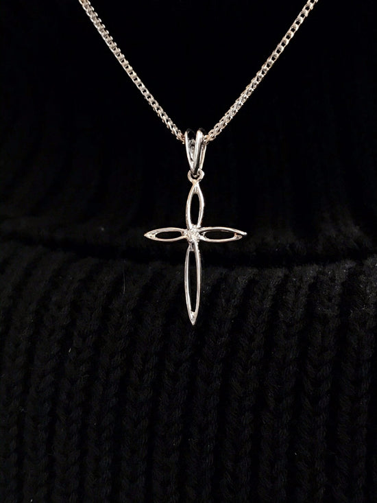 Photo of Diamond Cross Pendant in a decorative scene, designed by , available at Plumb Gold & Plumb Silver