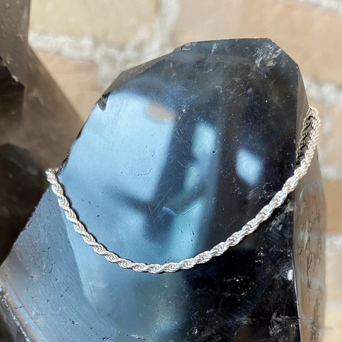 Photo of Diamond Cut Rope Bracelet in a decorative scene, designed by , available at Plumb Gold & Plumb Silver