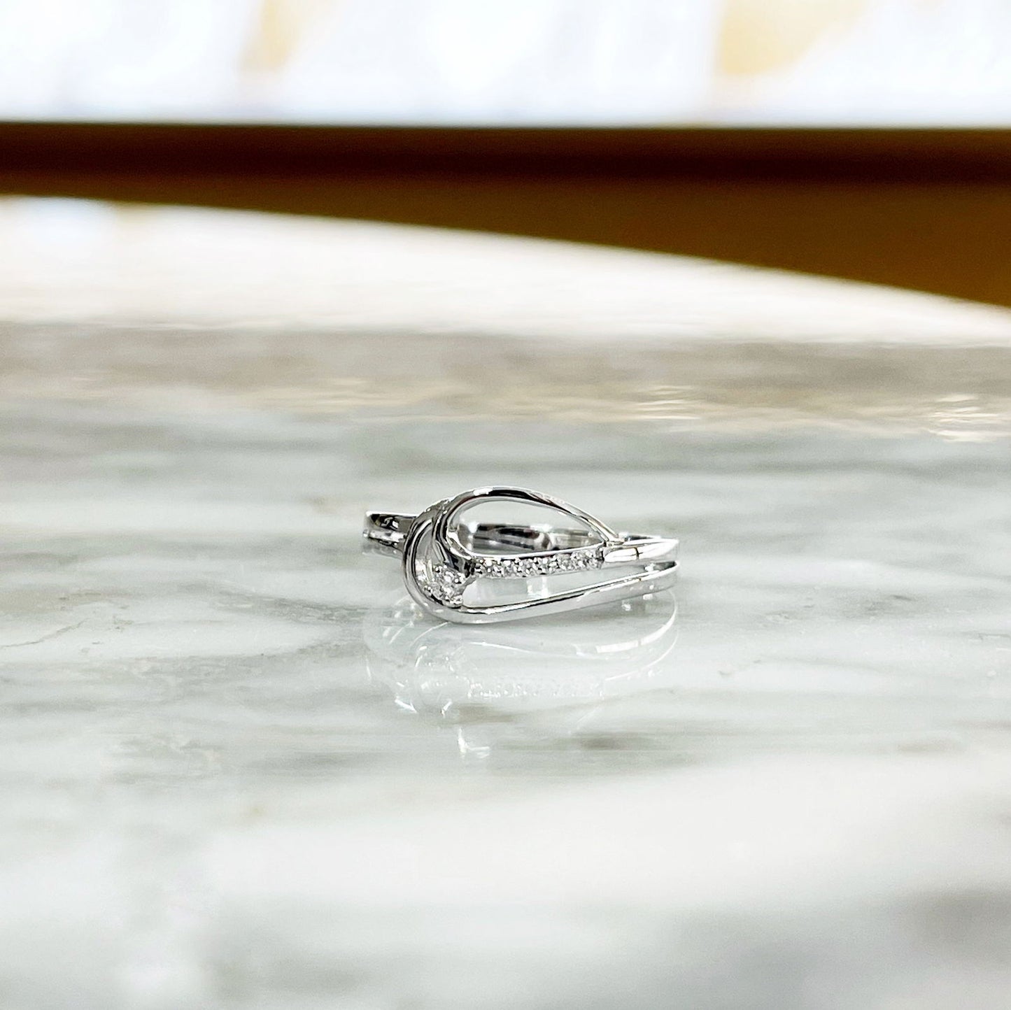Photo of Diamond Loop Ring in a decorative scene, designed by , available at Plumb Gold & Plumb Silver