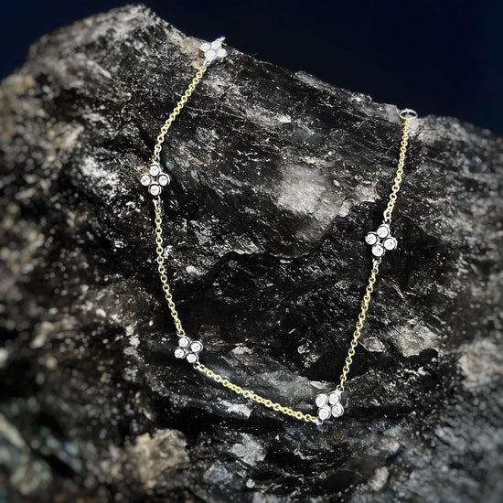 Photo of Diamond Quatrefoil Station Bracelet in a decorative scene, designed by , available at Plumb Gold & Plumb Silver