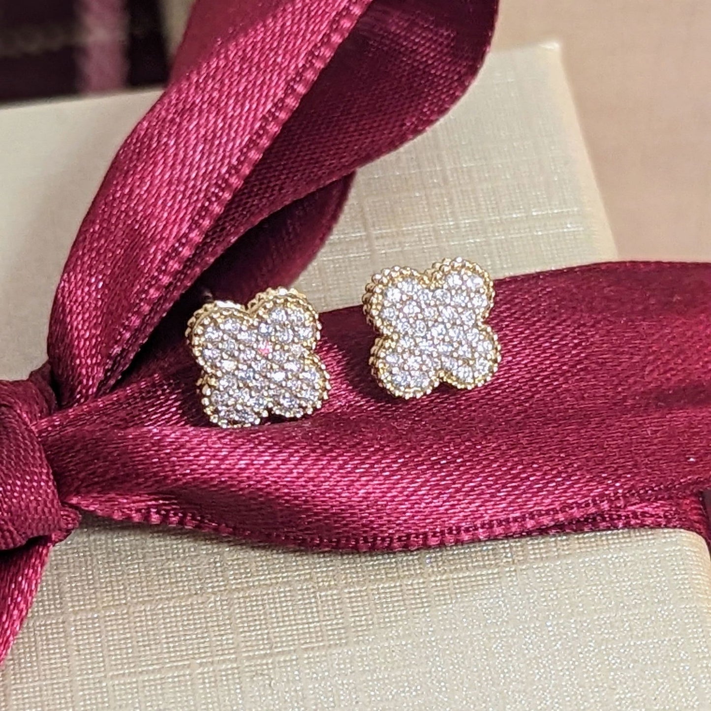 Photo of Diamond Quatrefoil Studs in a decorative scene, designed by , available at Plumb Gold & Plumb Silver