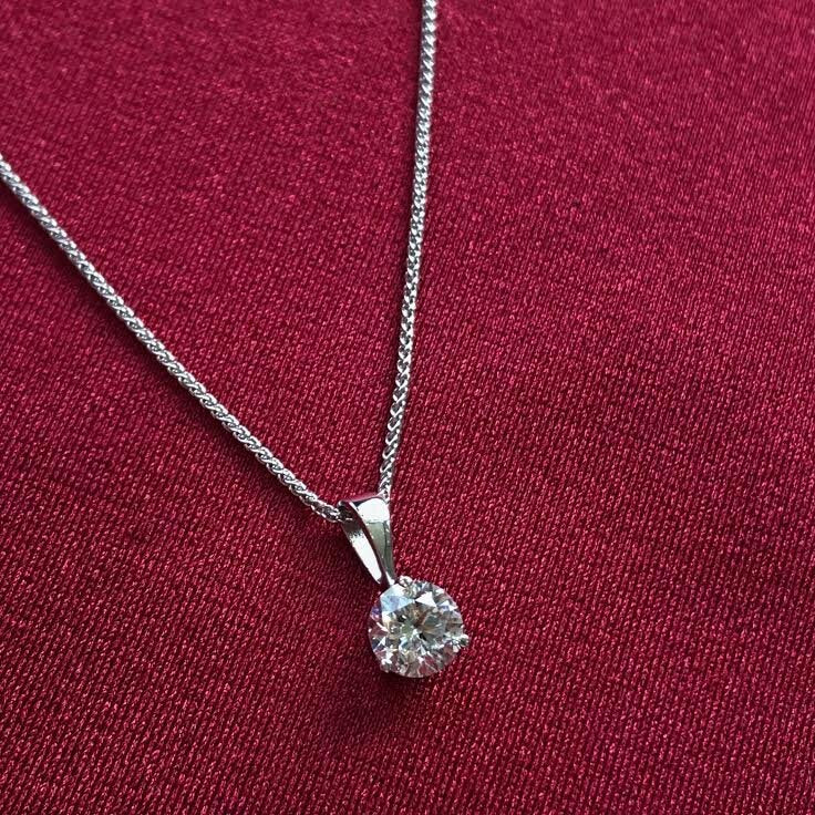 Photo of Diamond Solitaire Pendant in a decorative scene, designed by , available at Plumb Gold & Plumb Silver