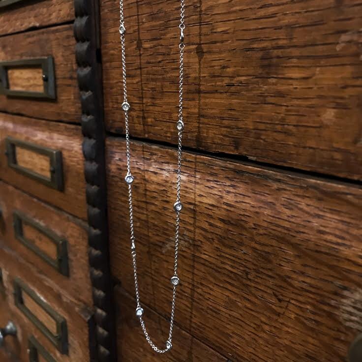 Photo of Diamond Station Necklace in a decorative scene, designed by , available at Plumb Gold & Plumb Silver