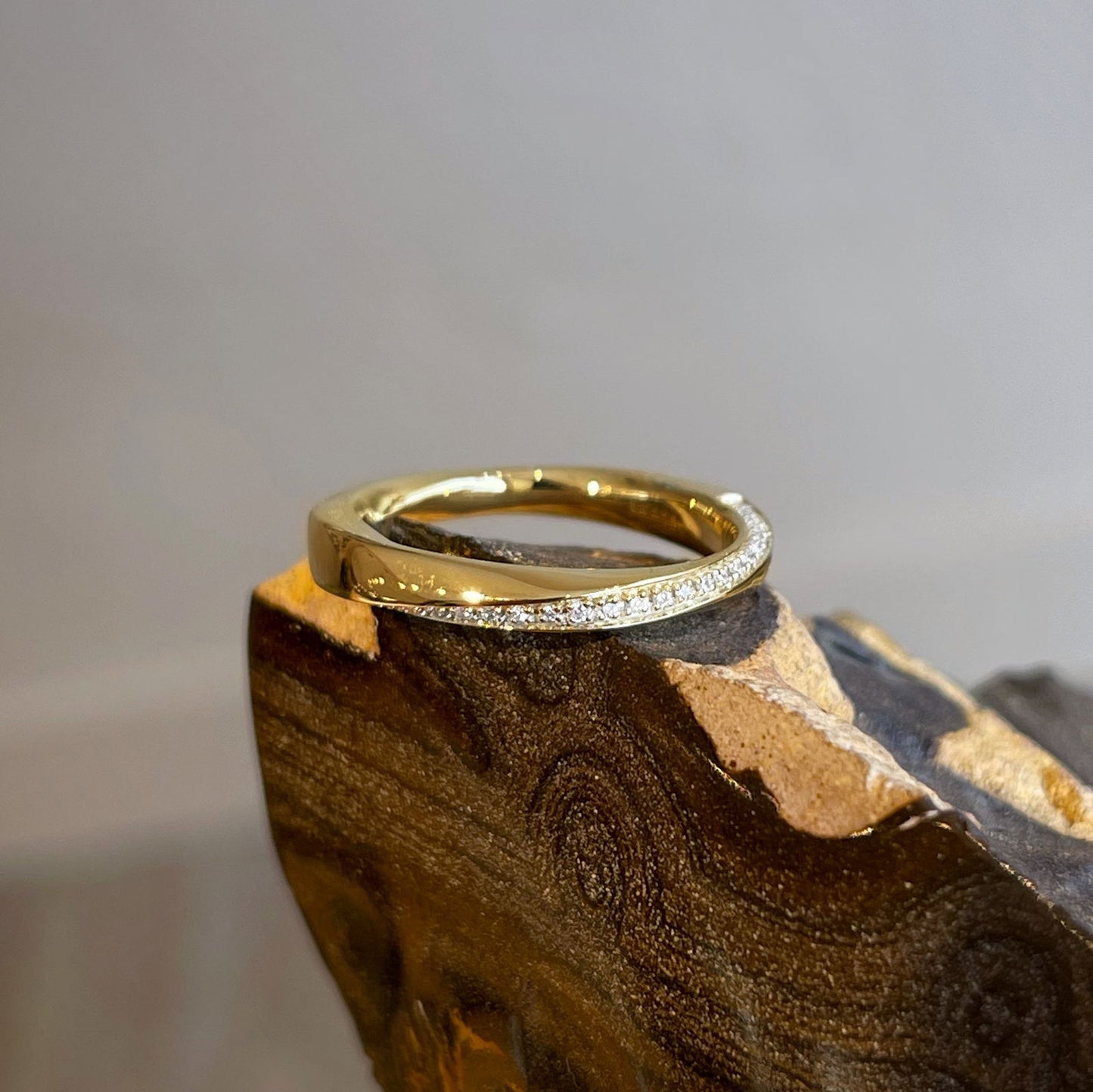 Photo of Diamond Twist Ring in a decorative scene, designed by , available at Plumb Gold & Plumb Silver