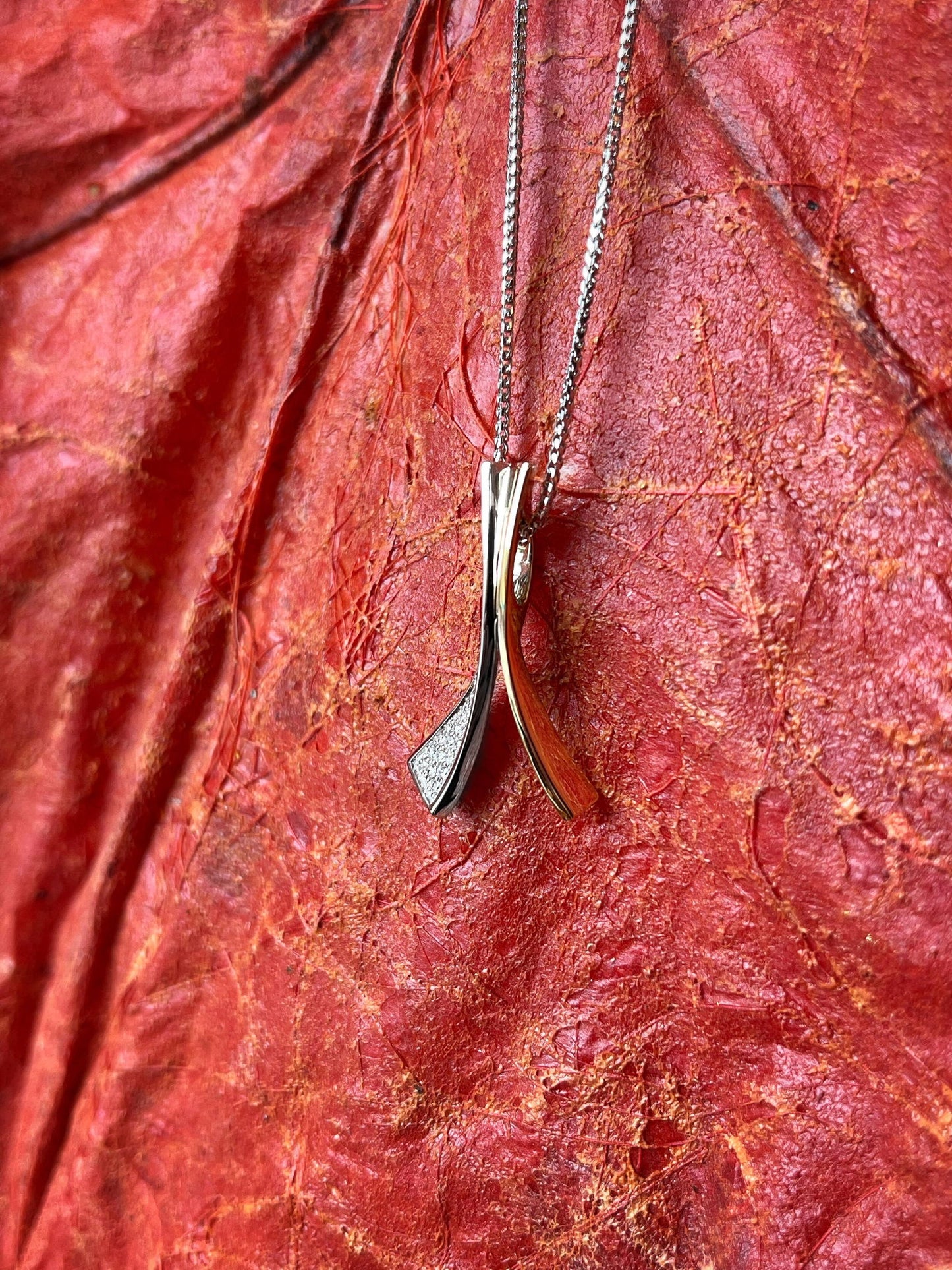 Photo of Diamond Wish Pendant in a decorative scene, designed by , available at Plumb Gold & Plumb Silver