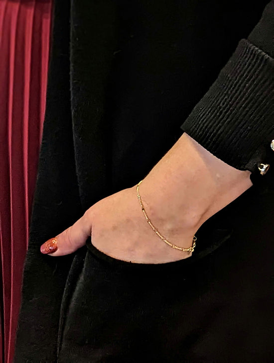 Photo of Disc station bracelet in a decorative scene, designed by , available at Plumb Gold & Plumb Silver