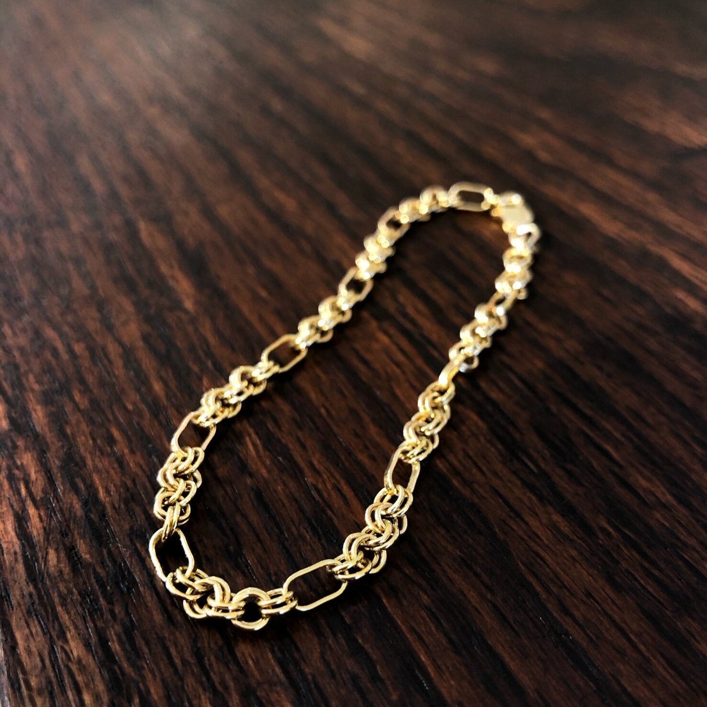 Photo of Double Circle Link Bracelet in a decorative scene, designed by , available at Plumb Gold & Plumb Silver