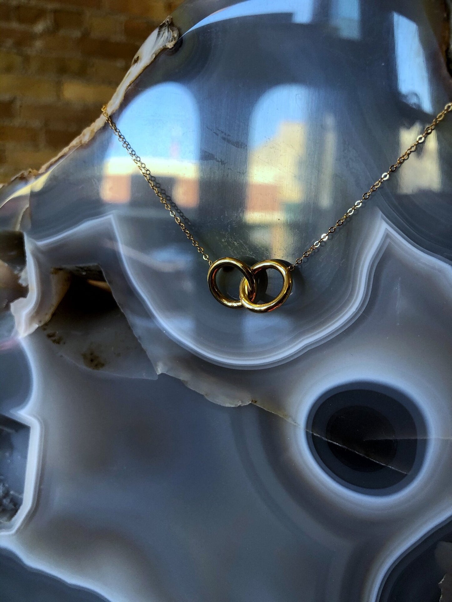 Photo of Double Circle Necklace in a decorative scene, designed by , available at Plumb Gold & Plumb Silver