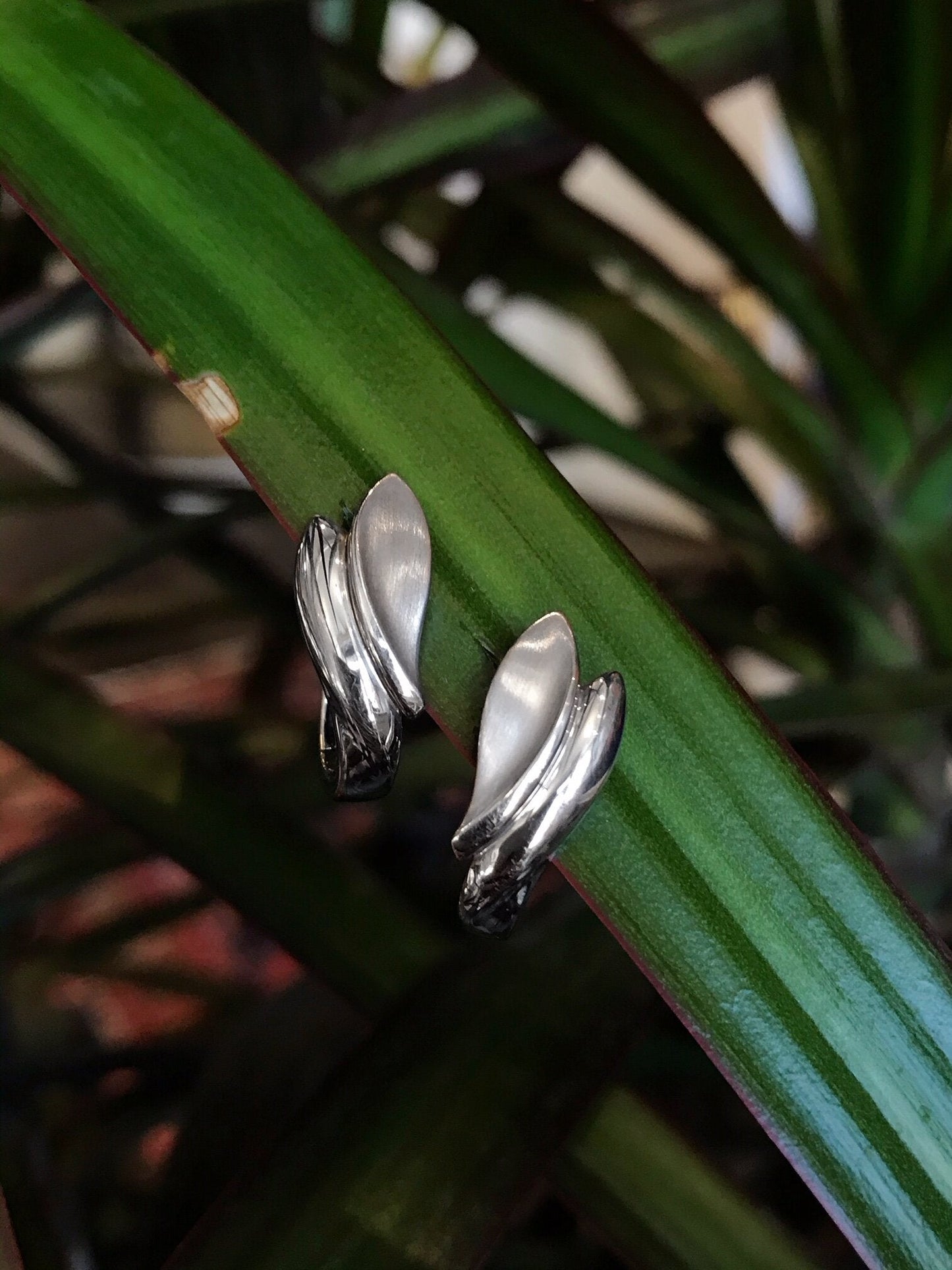 Photo of Double Leaf Earrings in a decorative scene, designed by , available at Plumb Gold & Plumb Silver