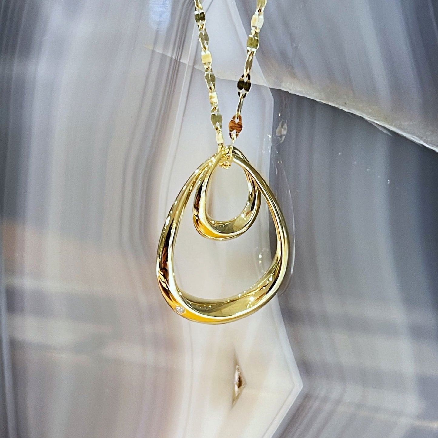 Photo of Double Oval Pendant in a decorative scene, designed by , available at Plumb Gold & Plumb Silver