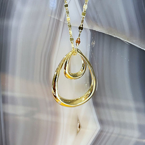 Photo of Double Oval Pendant in a decorative scene, designed by , available at Plumb Gold & Plumb Silver