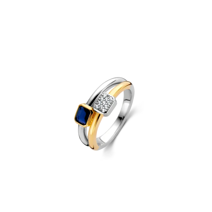 Photo of "Duo" Blue Bezel CZ Cluster Ring in a decorative scene, designed by , available at Plumb Gold & Plumb Silver