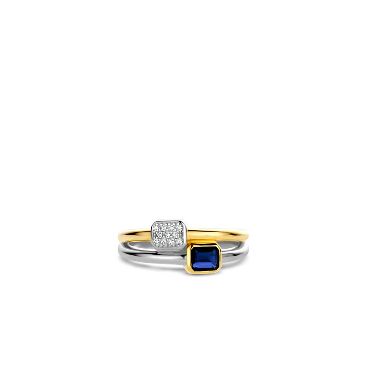 Photo of "Duo" Blue Bezel CZ Cluster Ring in a decorative scene, designed by , available at Plumb Gold & Plumb Silver