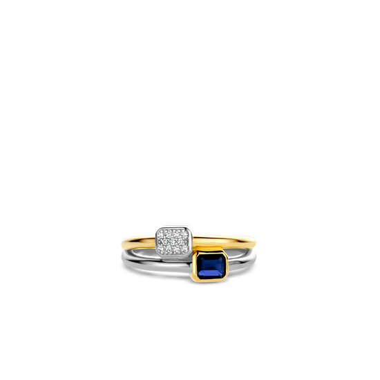 Photo of "Duo" Blue Bezel CZ Cluster Ring in a decorative scene, designed by , available at Plumb Gold & Plumb Silver