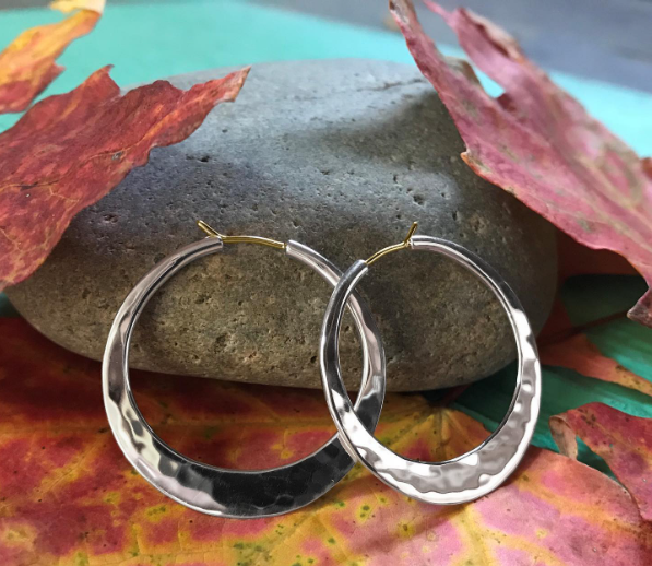 Photo of EL Design Large "Hammered" Flat Hoop Earrings in a decorative scene, designed by , available at Plumb Gold & Plumb Silver