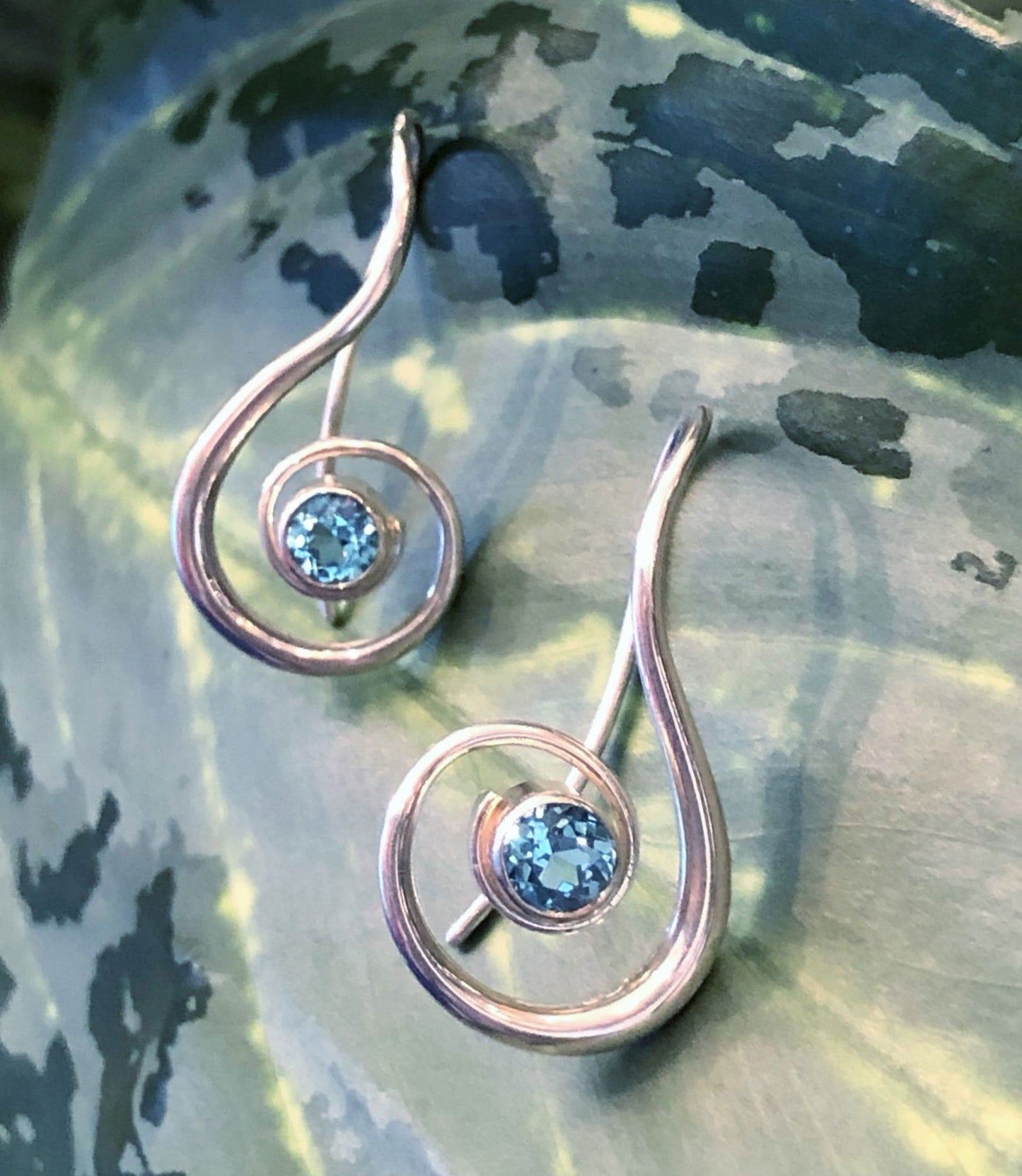 Photo of EL Designs Blue Topaz "Lyrical" Earrings in a decorative scene, designed by , available at Plumb Gold & Plumb Silver
