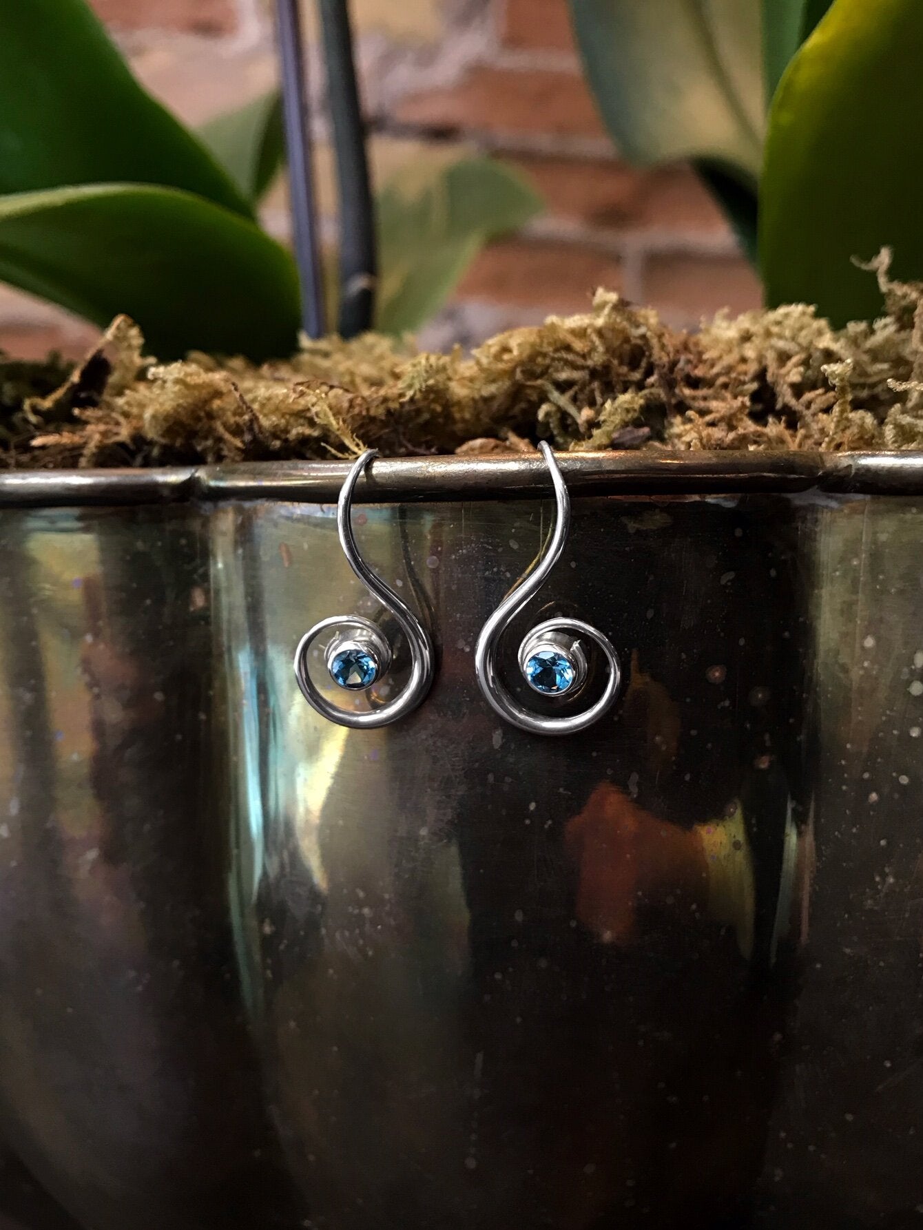 Photo of EL Designs Blue Topaz "Lyrical" Earrings in a decorative scene, designed by , available at Plumb Gold & Plumb Silver