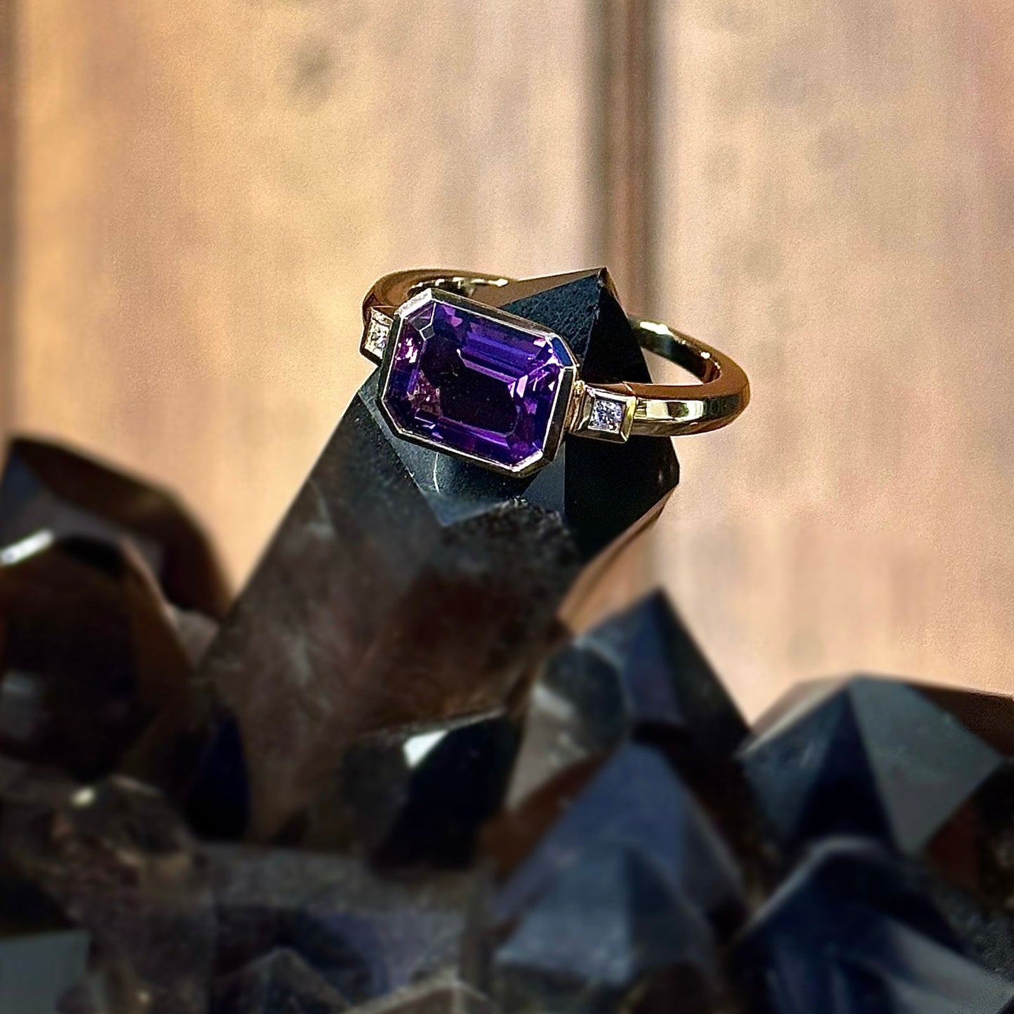 Photo of Emerald Cut Amethyst and Diamond Ring in a decorative scene, designed by , available at Plumb Gold & Plumb Silver