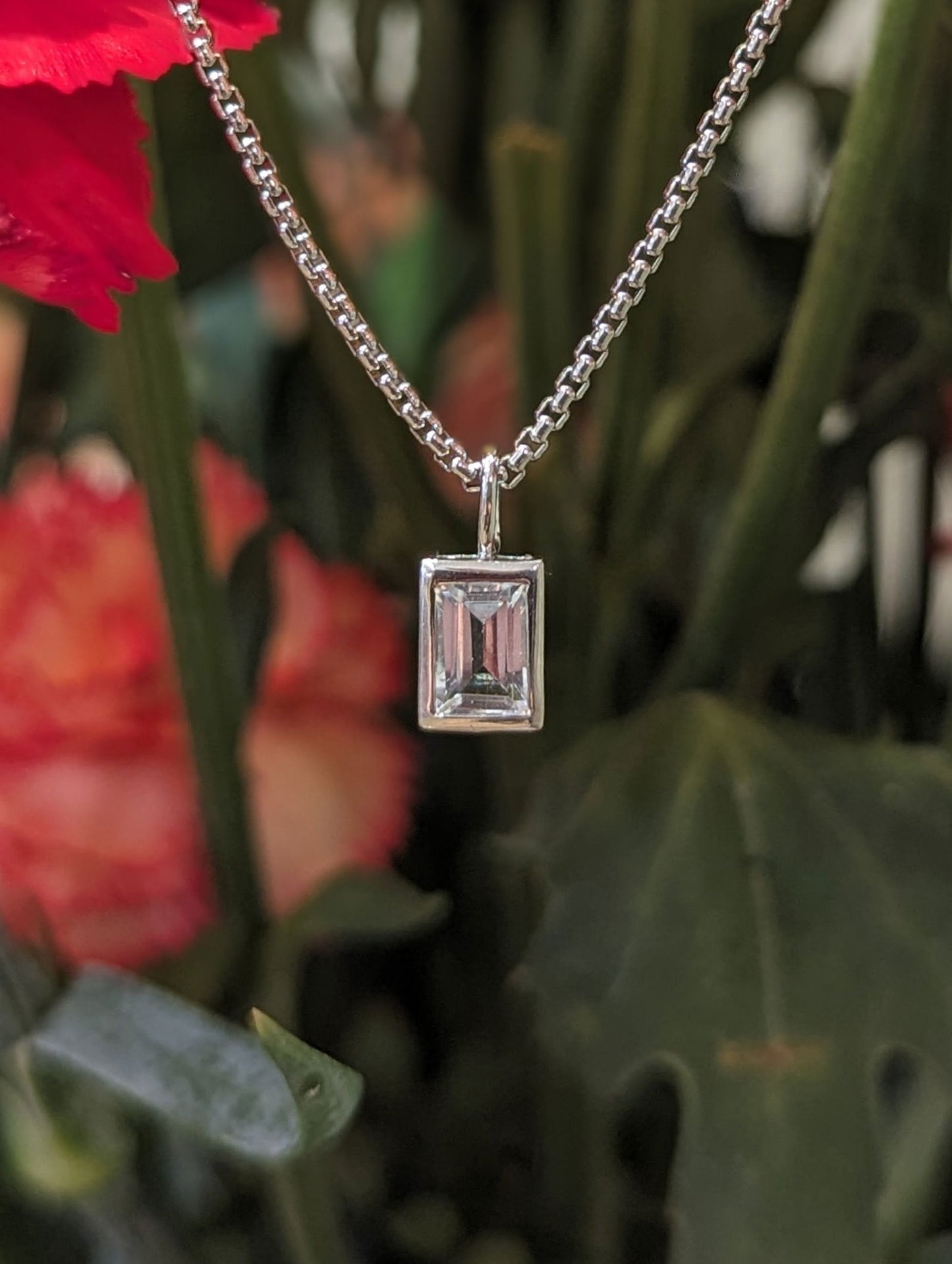 Photo of Emerald Cut Clear Quartz Pendant in a decorative scene, designed by , available at Plumb Gold & Plumb Silver