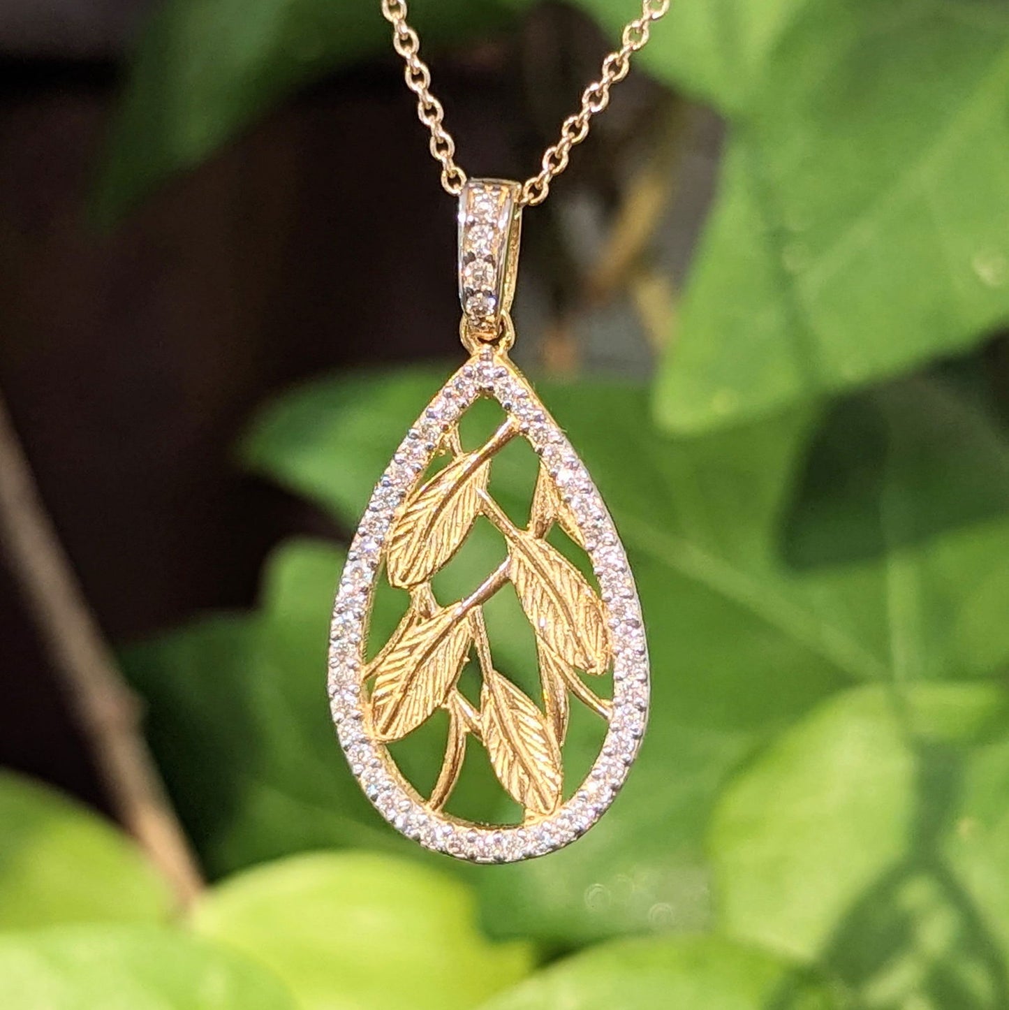 Photo of Etched leaf Diamond accented necklace in a decorative scene, designed by , available at Plumb Gold & Plumb Silver