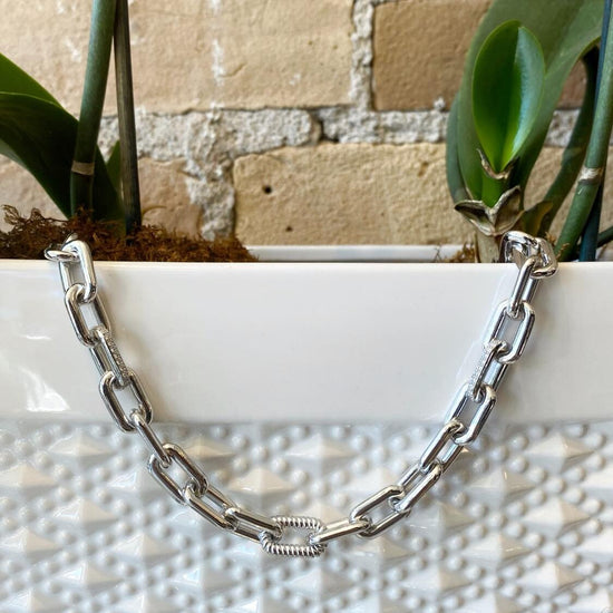 Photo of Fancy Square Link Necklace in a decorative scene, designed by , available at Plumb Gold & Plumb Silver