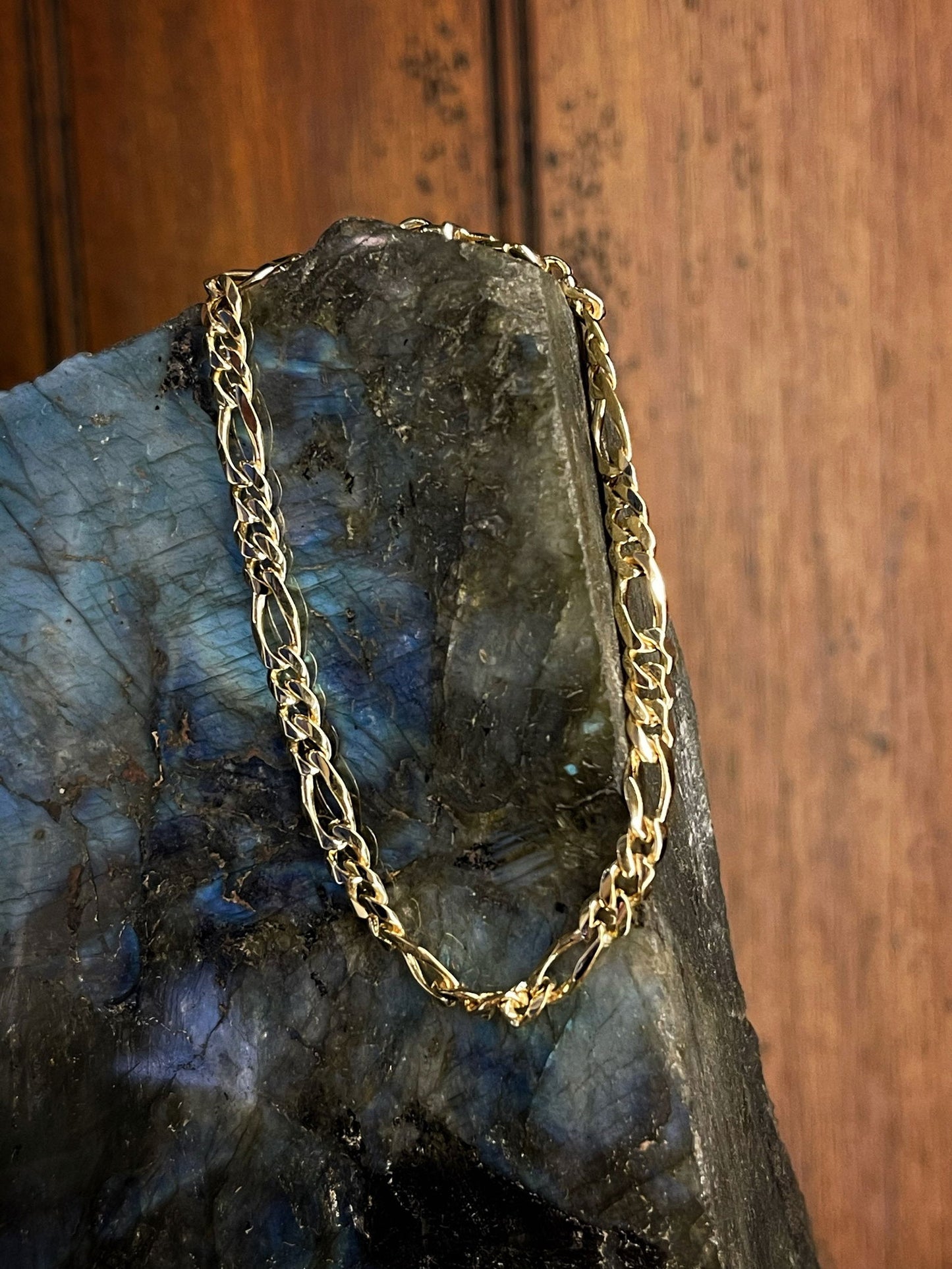 Photo of Figaro Bracelet in a decorative scene, designed by , available at Plumb Gold & Plumb Silver