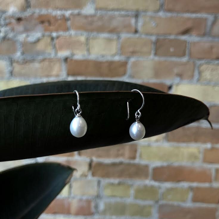 Photo of Freshwater Pearl Drop Earrings in a decorative scene, designed by , available at Plumb Gold & Plumb Silver