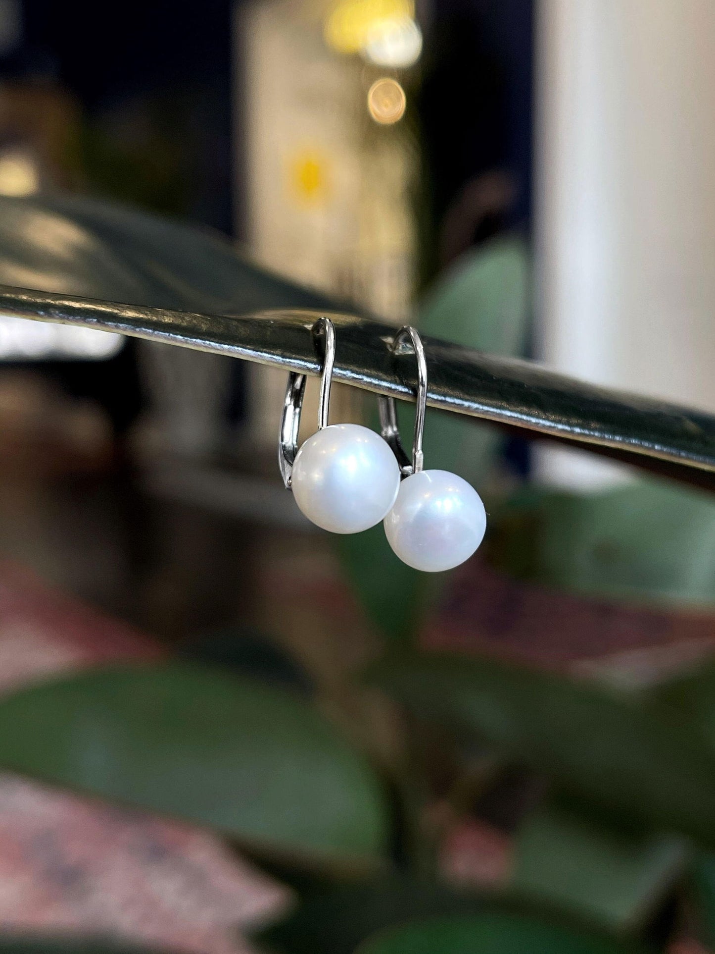 Photo of Freshwater Pearl Drop Earrings in a decorative scene, designed by , available at Plumb Gold & Plumb Silver