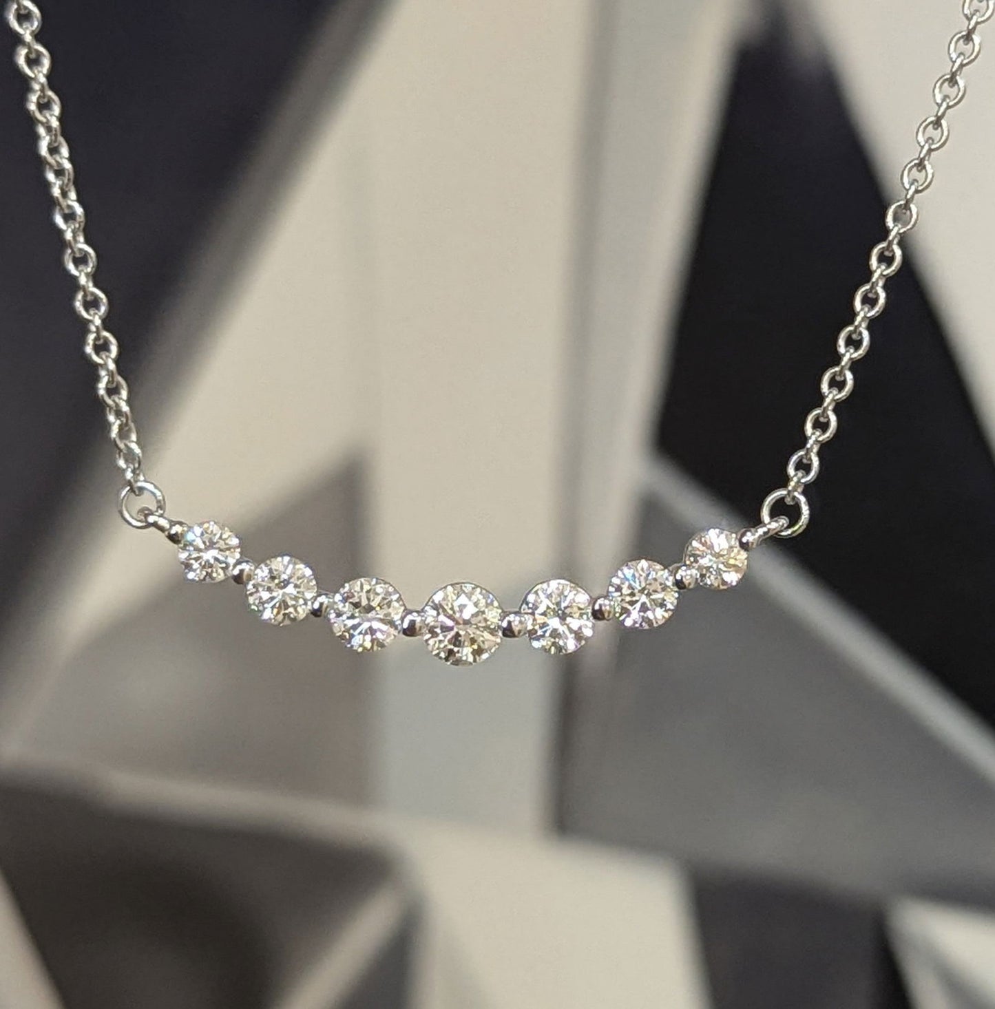 Photo of "Gabby" Smile Line Necklace in a decorative scene, designed by , available at Plumb Gold & Plumb Silver