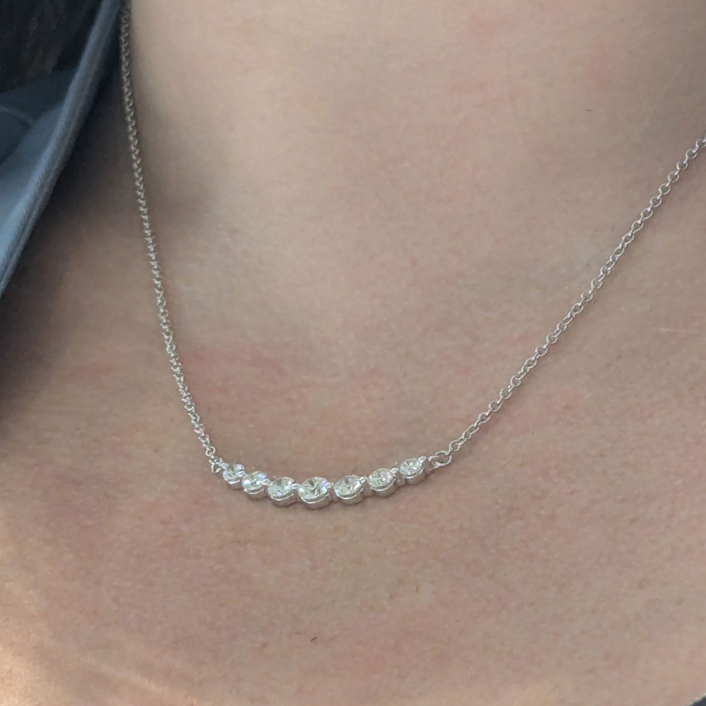 Photo of "Gabby" Smile Line Necklace in a decorative scene, designed by , available at Plumb Gold & Plumb Silver