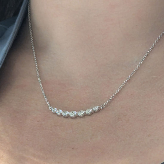 Photo of "Gabby" Smile Line Necklace in a decorative scene, designed by , available at Plumb Gold & Plumb Silver