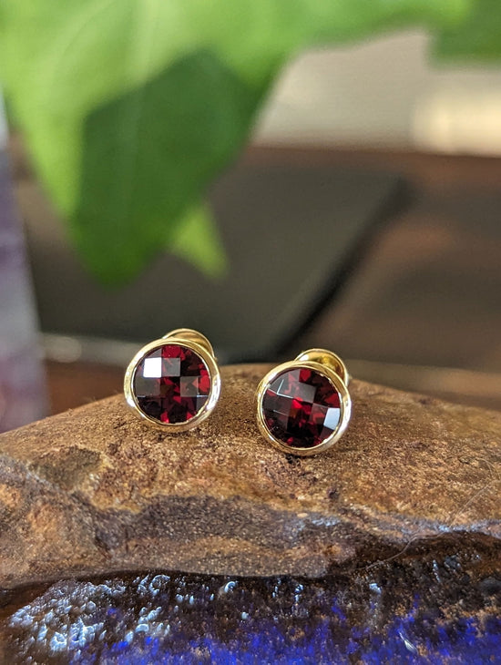 Photo of Garnet Bezel Studs in a decorative scene, designed by , available at Plumb Gold & Plumb Silver