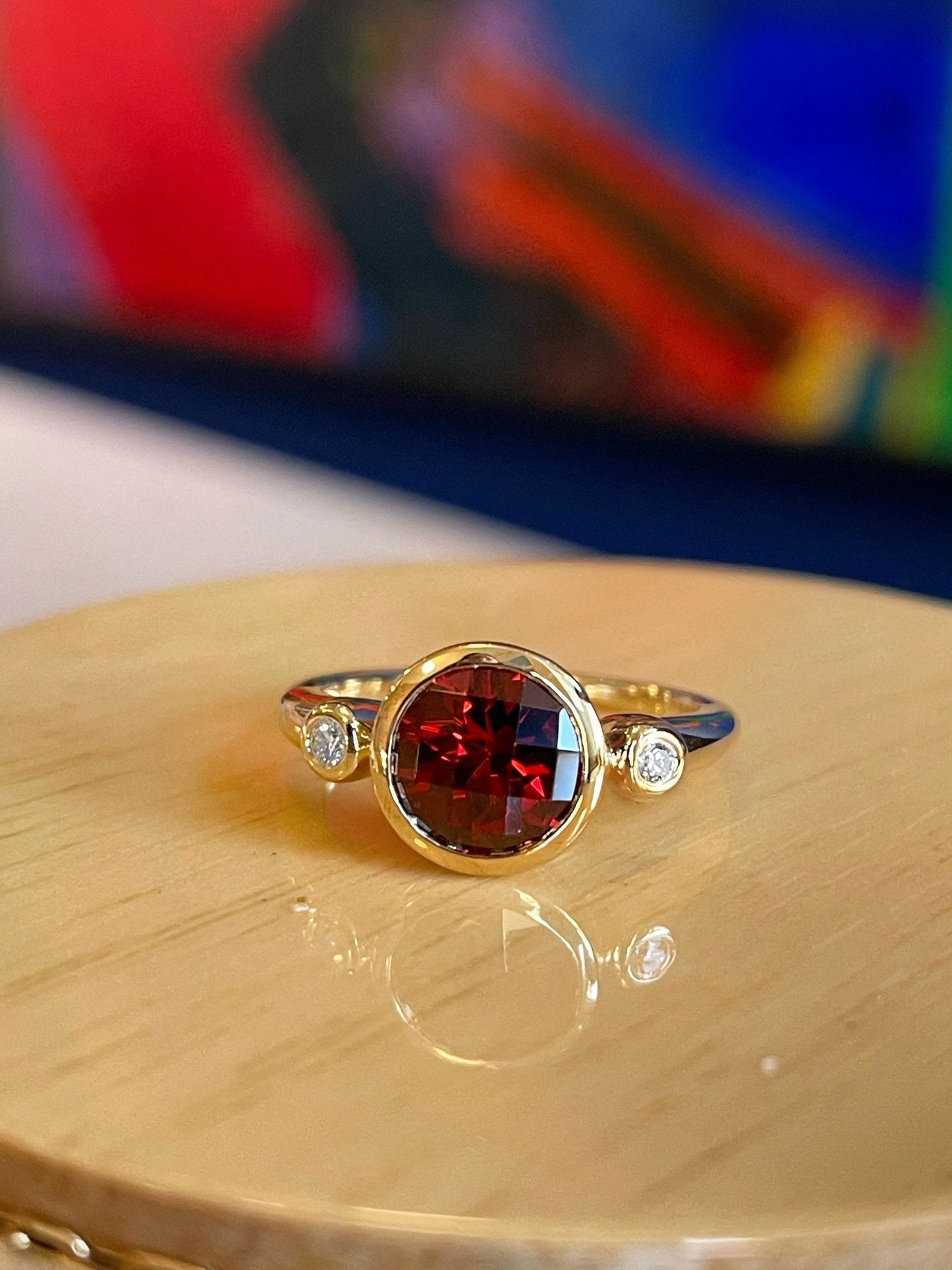 Photo of Garnet and Diamond Ring in a decorative scene, designed by , available at Plumb Gold & Plumb Silver