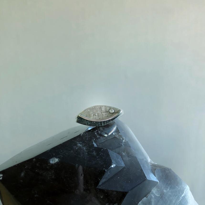 Photo of Gemoetric Leaf Ring with Diamond Accent in a decorative scene, designed by , available at Plumb Gold & Plumb Silver