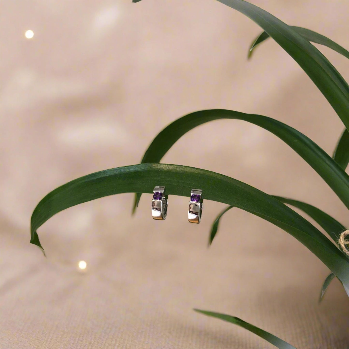 Photo of Gemstone Huggie Earrings in a decorative scene, designed by , available at Plumb Gold & Plumb Silver