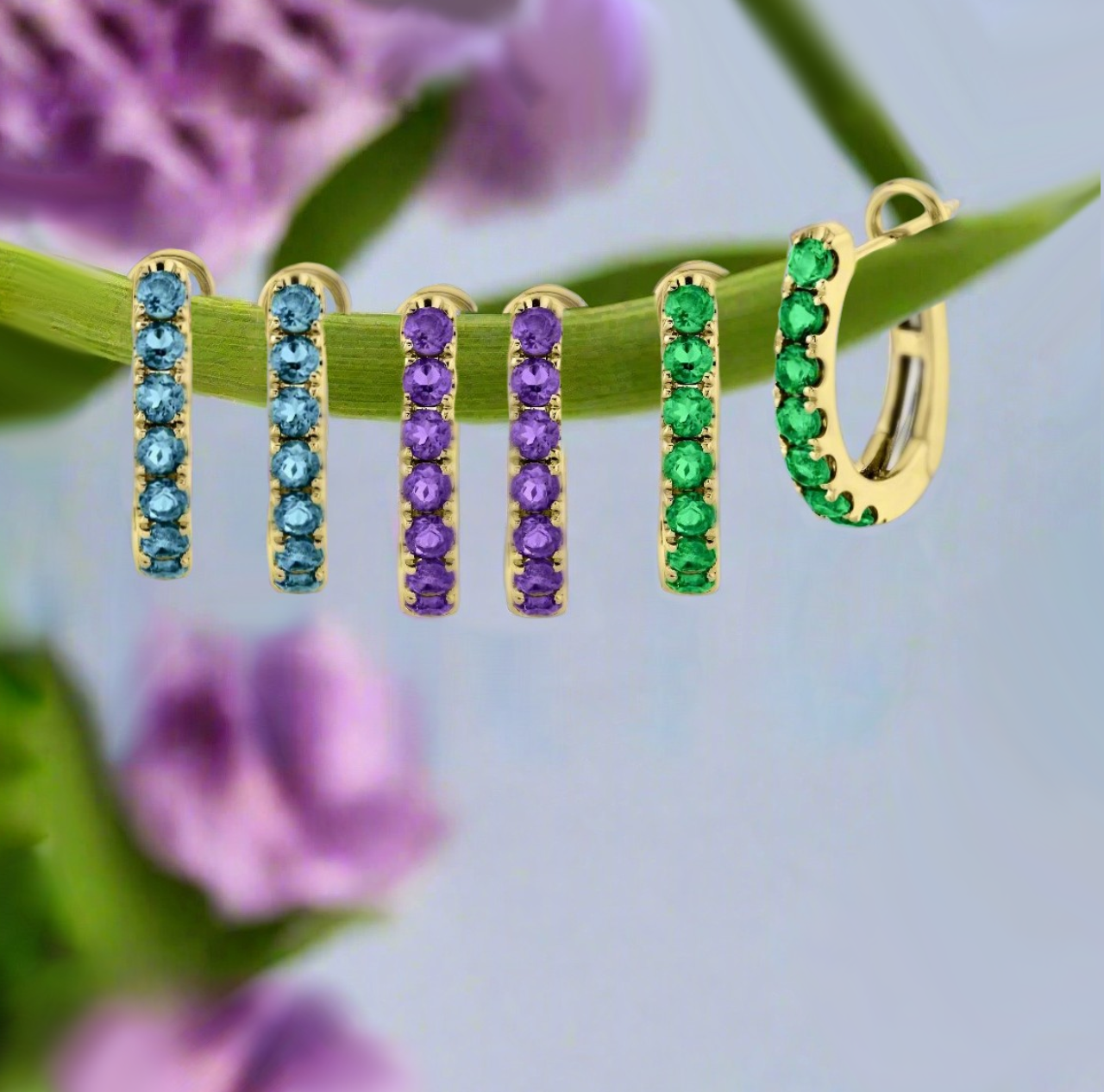 Photo of Gemstone Huggies in a decorative scene, designed by -, available at Plumb Gold & Plumb Silver