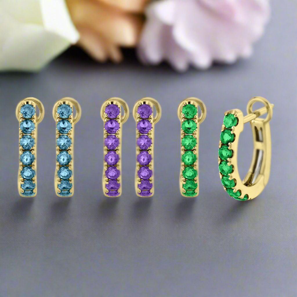 Photo of Gemstone Huggies in a decorative scene, designed by -, available at Plumb Gold & Plumb Silver