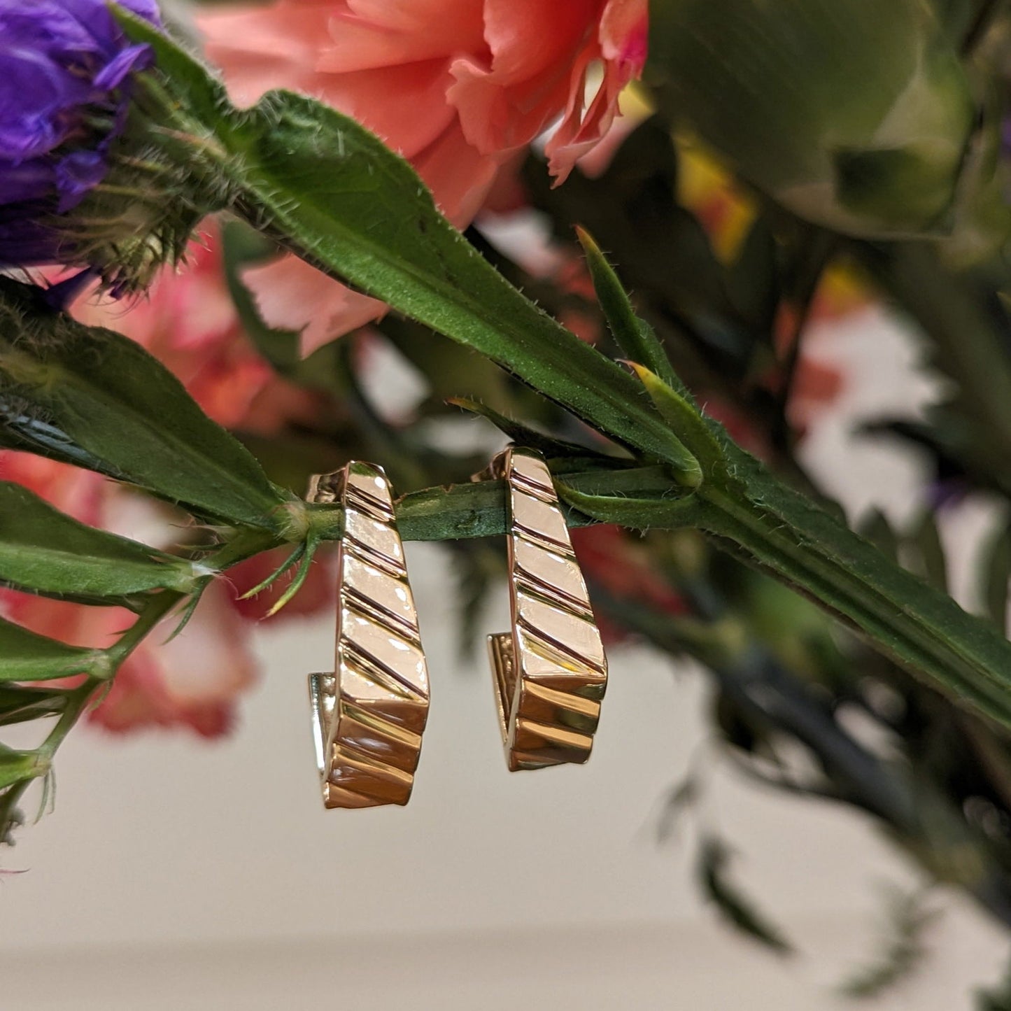 Photo of Geometric J-Hoop in a decorative scene, designed by , available at Plumb Gold & Plumb Silver