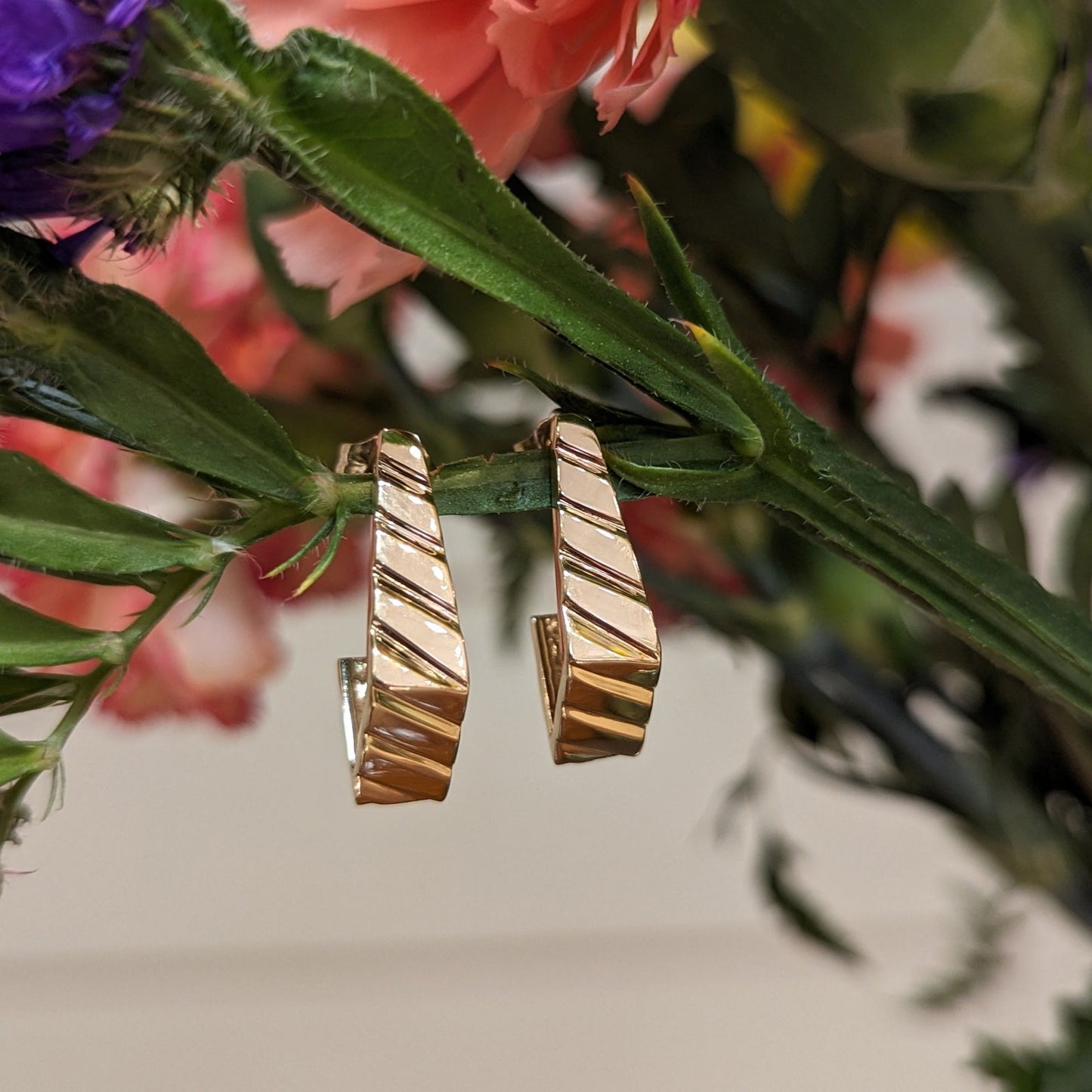 Photo of Geometric J-Hoop in a decorative scene, designed by , available at Plumb Gold & Plumb Silver