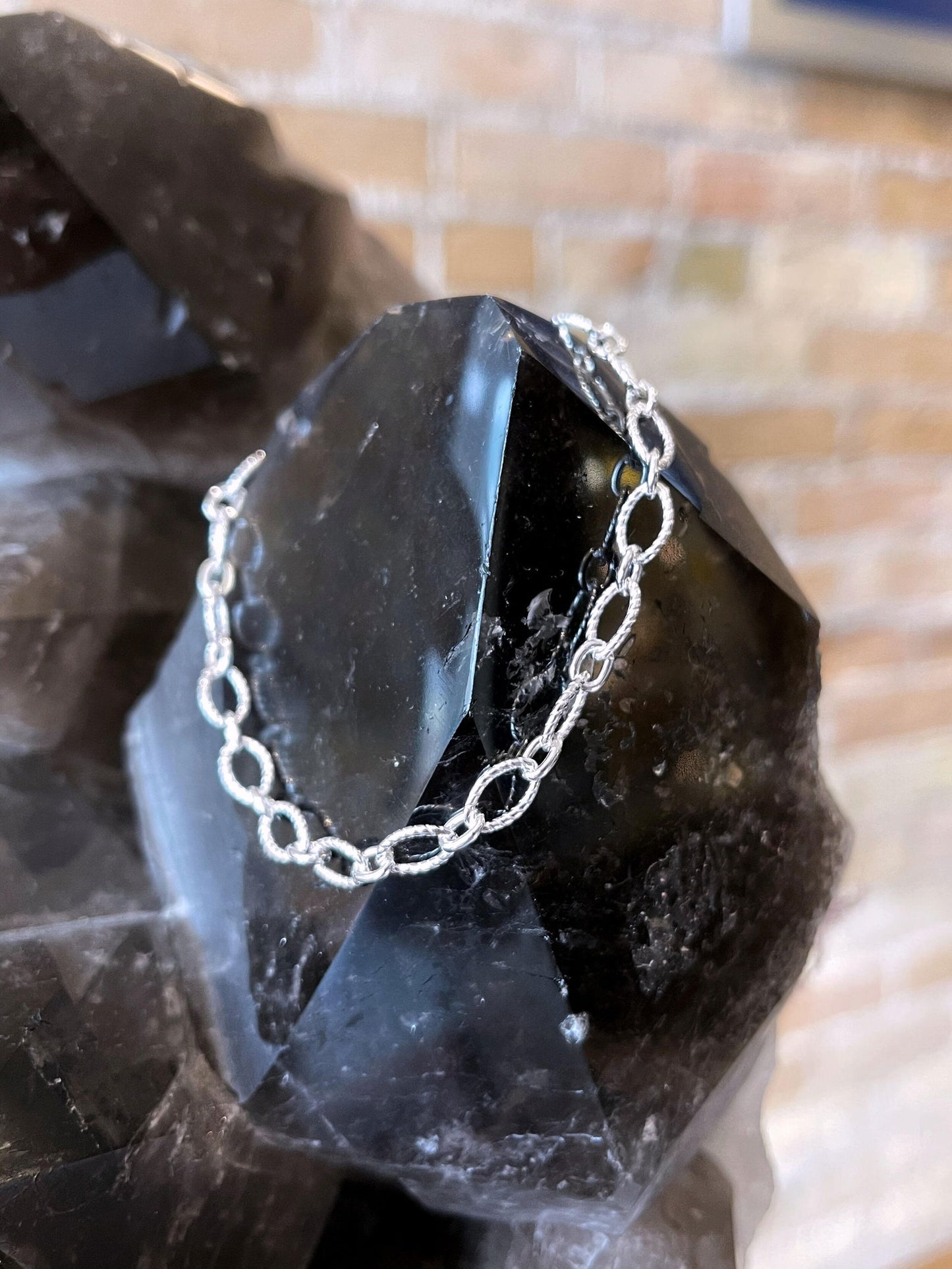 Photo of Gnarled Link Bracelet in a decorative scene, designed by , available at Plumb Gold & Plumb Silver