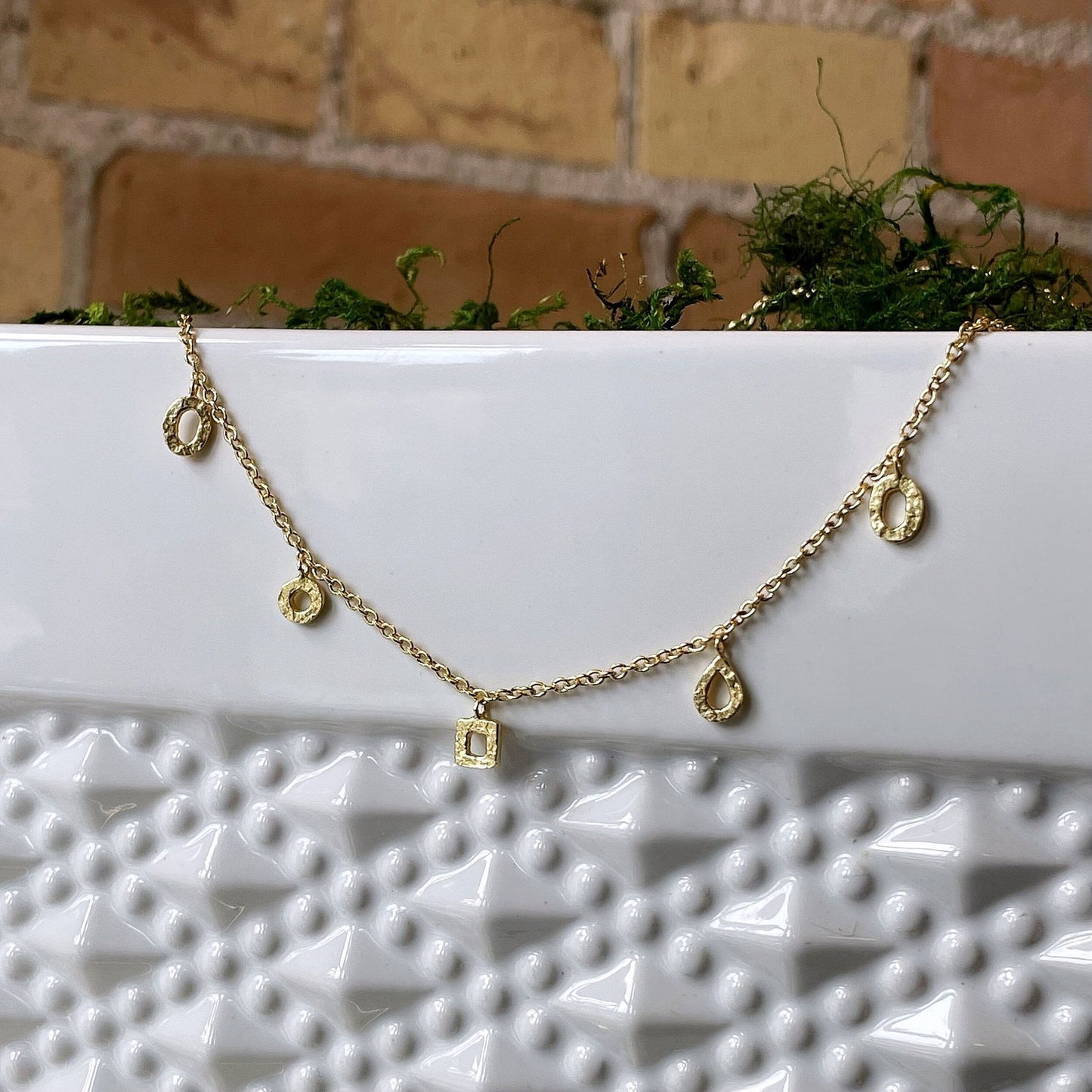Photo of “Gold Drops” Necklace in a decorative scene, designed by , available at Plumb Gold & Plumb Silver