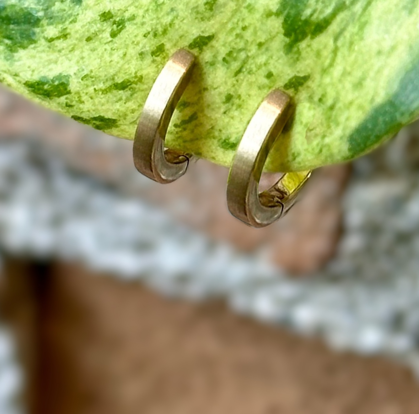 Photo of Gold Small Flat Hoop in a decorative scene, designed by , available at Plumb Gold & Plumb Silver